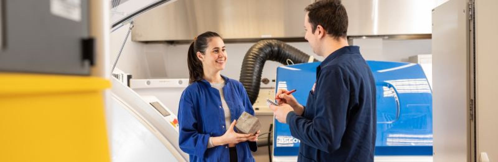 Image of student in the civil engineering lab at the University of Leeds holding some concrete.