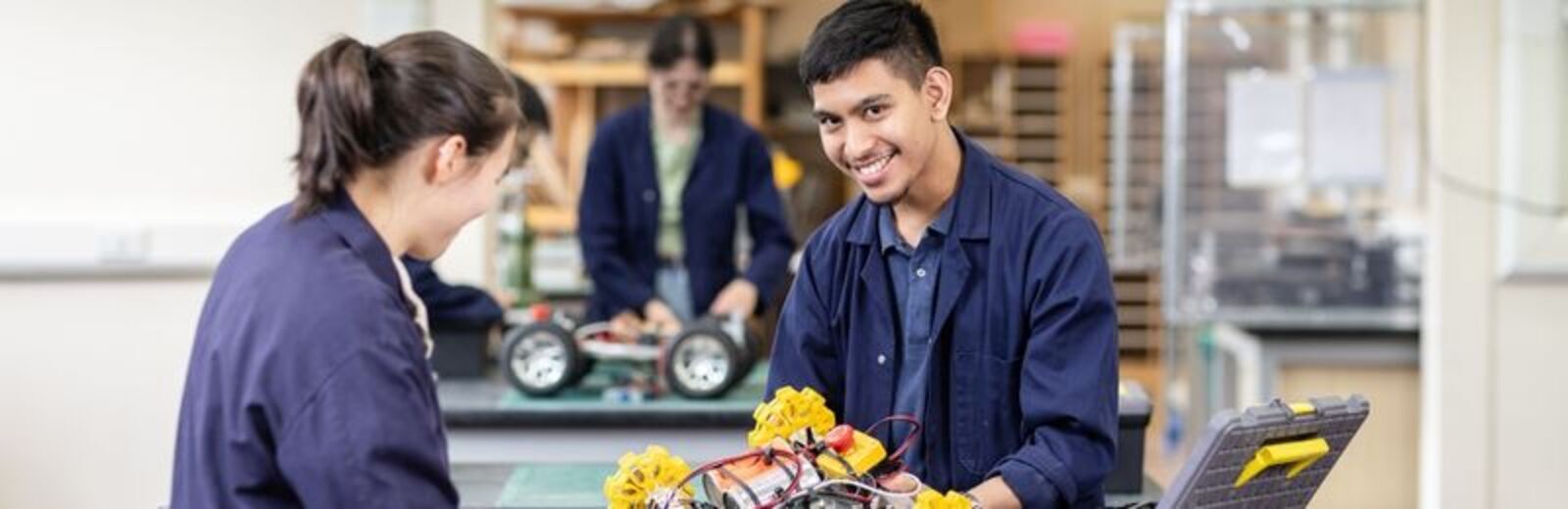 A photograph showing students in a mechanical engineering workshop working on rovers.