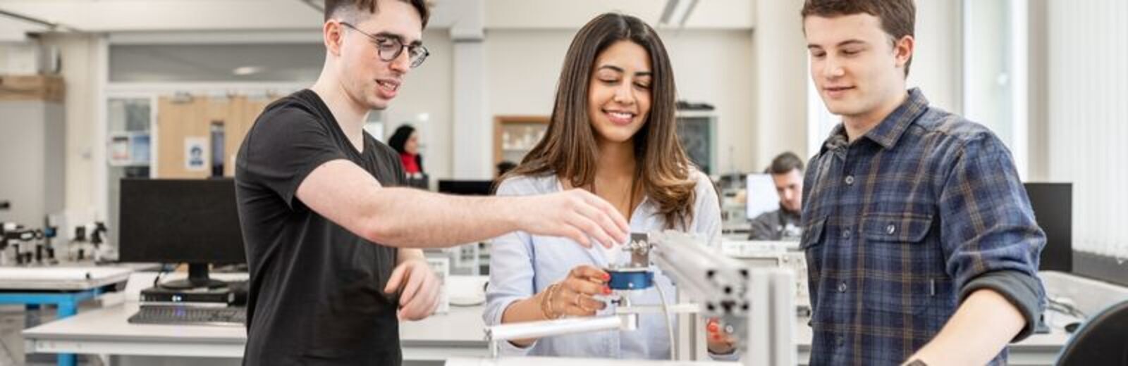 Three students working on a project in a electronics lab in the School of Electronic and Electrical Engineering.