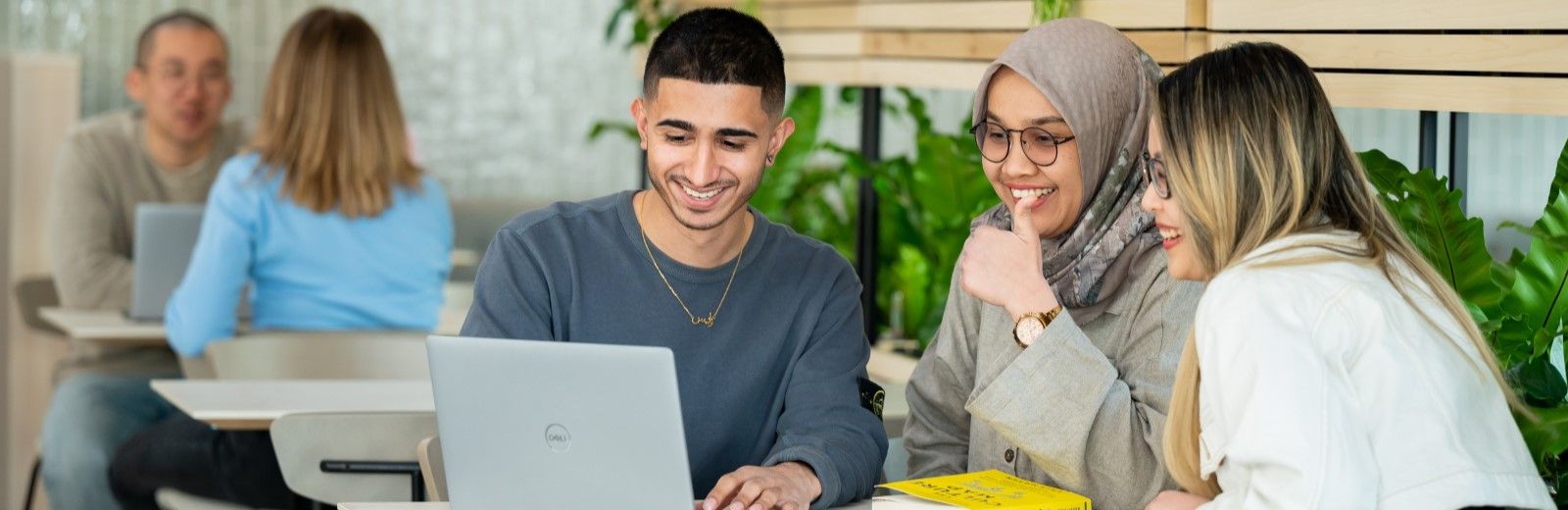 Students working on a laptop in a cafe