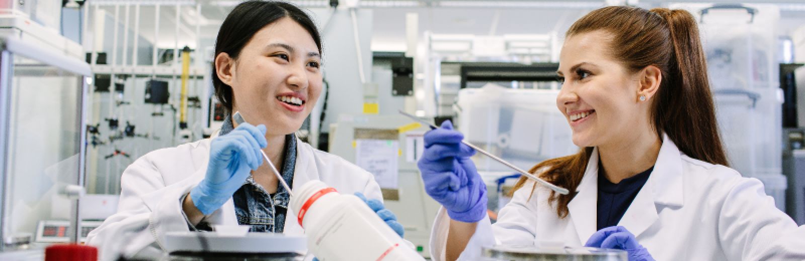 Two female students working in the lab with samples and pipettes