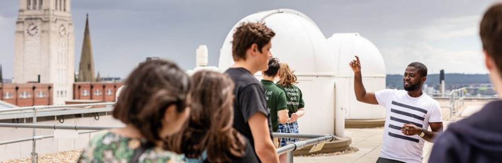 A group of people on the roof looking at the observatory at the University of Leeds.