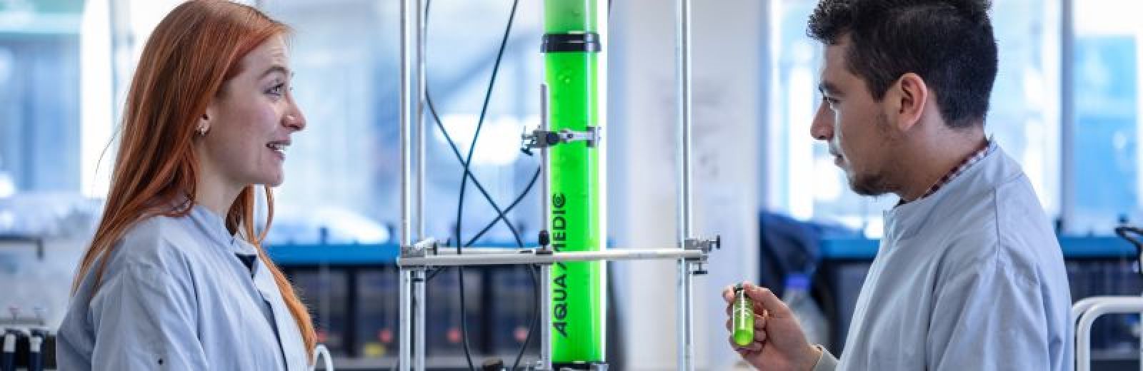 Two Civll masters students working with algae tubes.