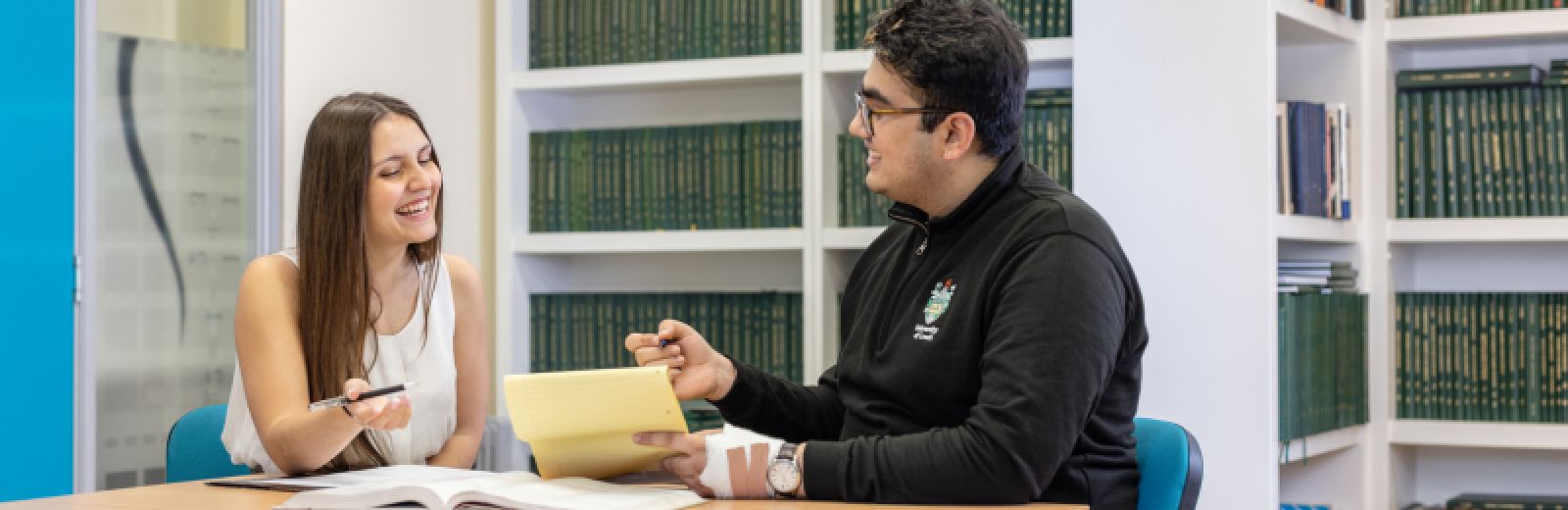 Maths student discuss project work in the reading room