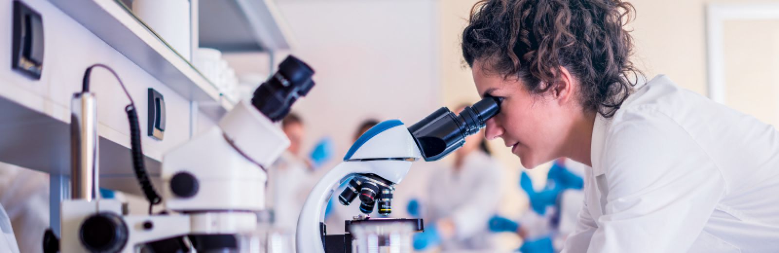 Student in the lab looking at a microscope